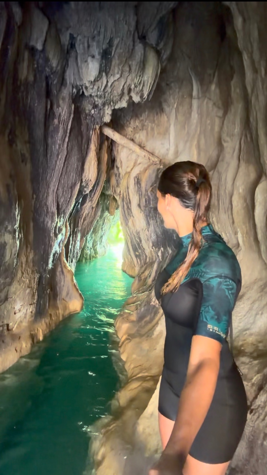 Explorando una cueva estrecha con agua turquesa
